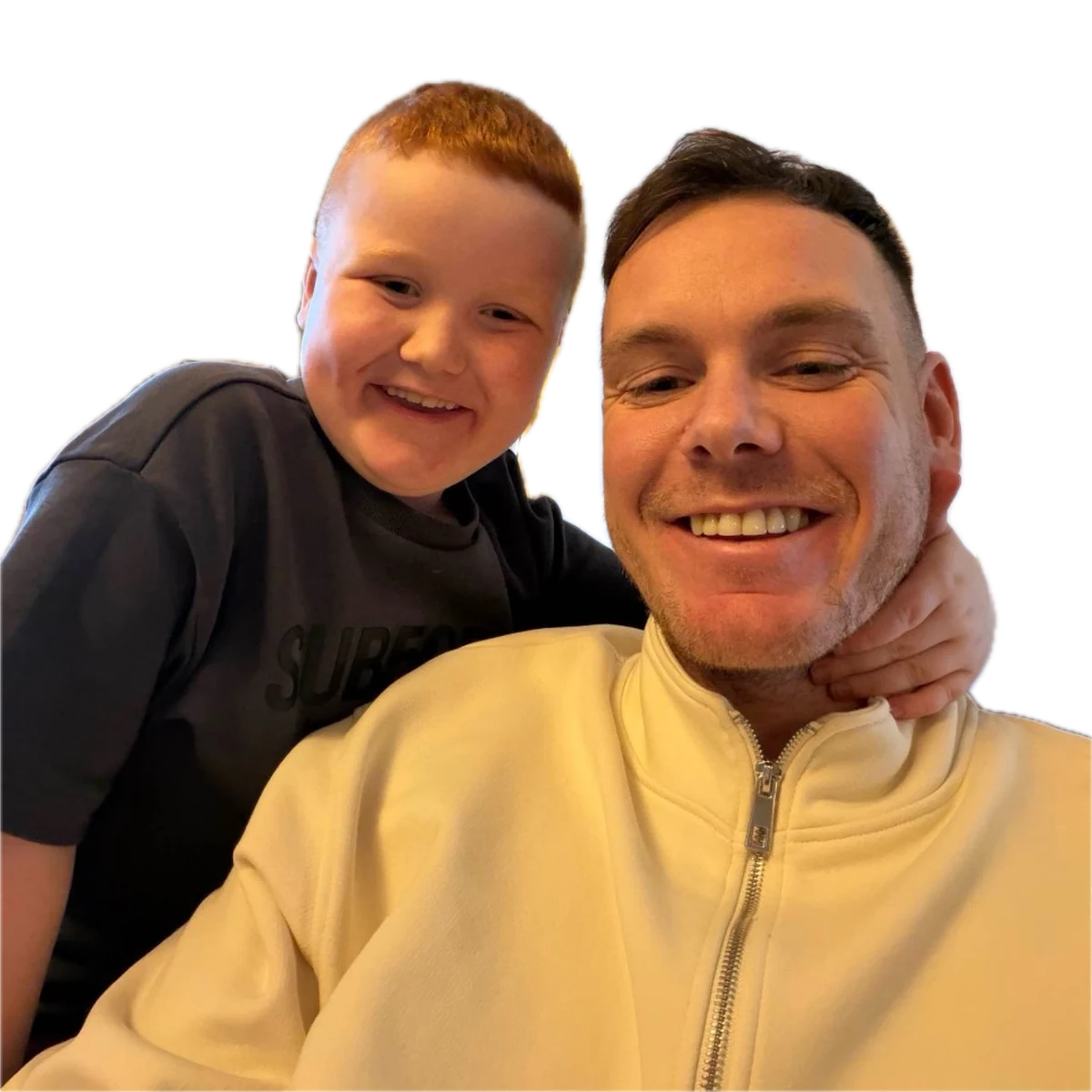 Jamie poses with a smiling boy in front of an elegant ceiling.