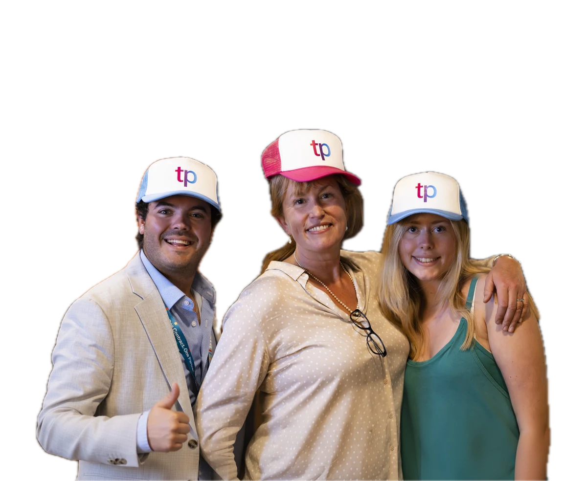 Three trialport team members wearing branded tp caps at an event and smiling.