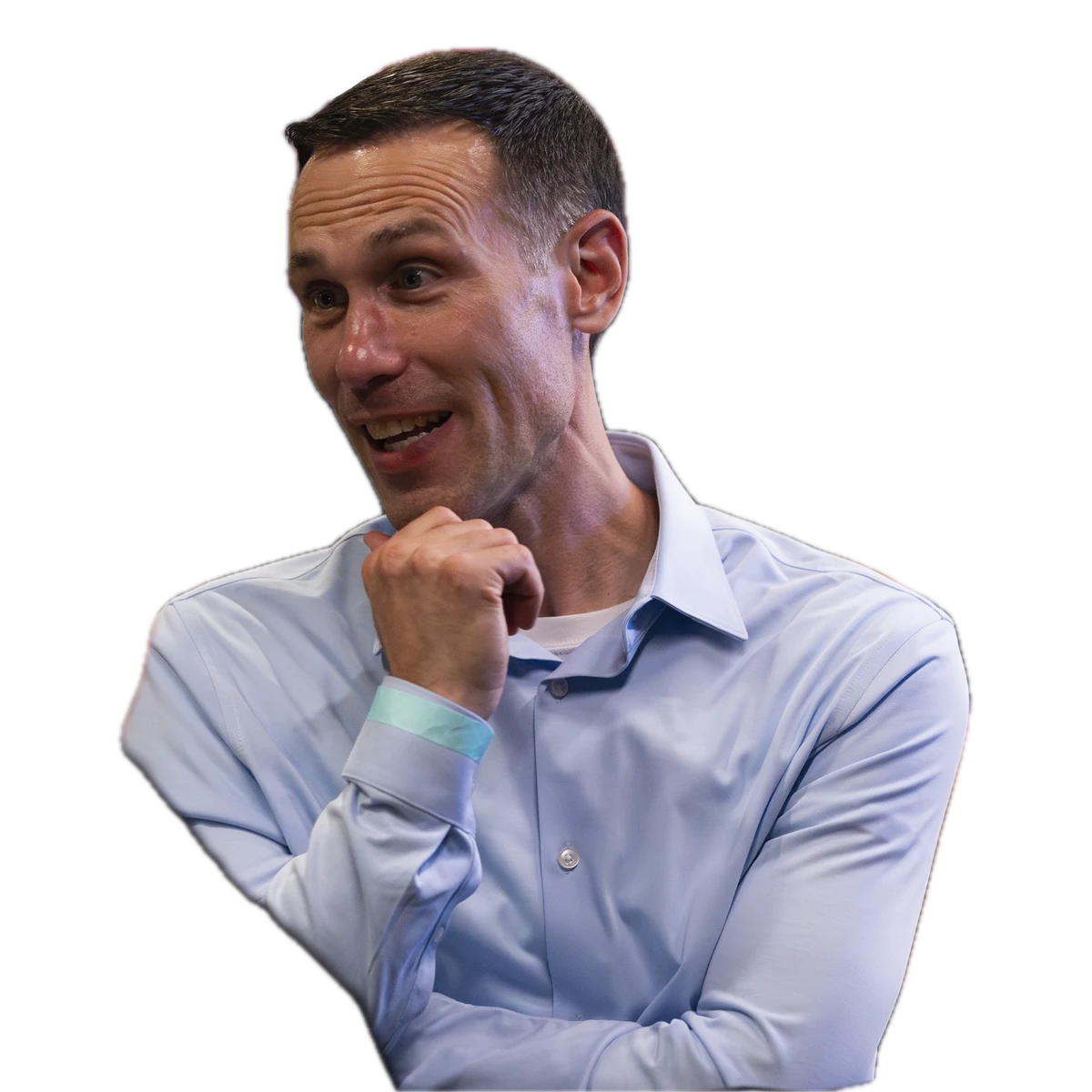 A man in a light blue shirt smiling during a conversation at a networking event